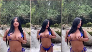 Natalia Galvis on the edge of the lake taking her breasts out of the bikini